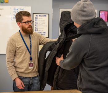 Caseworker provides winter coat to client